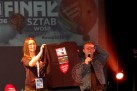 Zdjęcie przedstawia finał Wielkiej Orkiestry Świątecznej Pomocy (WOŚP) z 2016 roku. Na zdjęciu widoczna jest kobieta i mężczyzna trzymający czarną koszulkę z logo 24. Finału WOŚP. Na banerze w tle widnieje logo WOŚP i hasło 'Mierzymy Wysoko'.