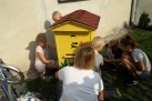 Dzieci wraz  z osobą dorosłą ozdabiają żółty ul. 
