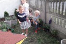 Na zdjęciu czwórka dzieci wśród roślin. Jedna z dziewczynek trzyma w dłoni sadzonkę. 