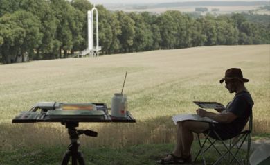 Artysta malujący, w tle ołtarz papieski otoczony polem dojrzałego zboża