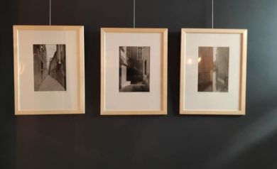 Na ścianie wiszą fotografie oprawione w drewniane ramki.