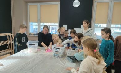 Dzieci wyszukują sobie kolory farb w jakich chcą mieć pomalowane miedziane wytwory.