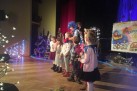 Na scenie znajdują się aktorzy grający w spektaklu teatralnym ,,Gdzie jesteś Mikołaju?' oraz dzieci. Scena udekorowana jest świątecznymi ozdobami. 
