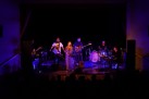 Na scenie występ zespołu Mikromusic. Sala oświetlona jest nastrojowym niebiesko-fioletowym światłem. 