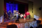 Na scenie znajdują się dzieci i aktorzy odgrywający scenę z spektaklu teatralnego ,,Gdzie jesteś Mikołaju?'. Scena udekorowana jest świątecznymi ozdobami. 