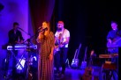 Zdjęcie przedstawia muzyków grających na instrumentach oraz wokalistkę. 