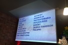 Na zdjęciu wyświetlacz, na którym widać slajd dotyczący odbywającego się wydarzenia,. 