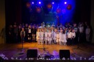 Na zdjęciu dzieci i młodzież stojące na scenie. Widać sprzęt muzyczny oraz ozdoby. 