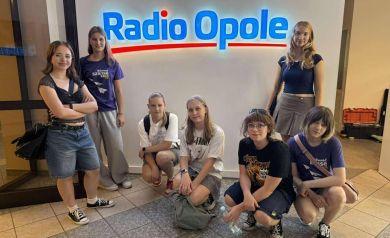 Na zdjęciu siedem dziewcząt przy szyldzie Radia Opole. - powiększ