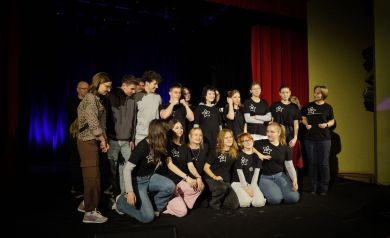 Grupa teatralna ustawiająca się do zdjęcia grupowego.