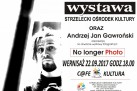 Plakat zapowiada wystawę fotografii „No longer Photo” Andrzeja Jana Gawrońskiego. Wernisaż odbył się 22.09.2017 o godzinie 18:00 w C@fe Kultura przy Strzeleckim Ośrodku Kultury. Kolorystyka jest czarno-biała z czerwonym akcentem w słowie „Photo”, co nadaje plakatowi mocny kontrast. Grafika to portret mężczyzny z aparatem, przedstawiony w surowym, kontrastowym stylu. Logo SOK jest kolorowe i dynamiczne, a obok niego podano dane kontaktowe ośrodka. 