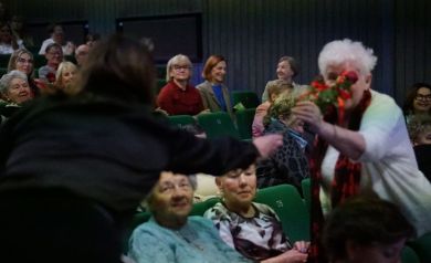 Moment wręczania przez kobietę róży kobiecie w jasnych włosach.