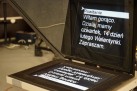 Na zdjęciu widoczny jest prompter, urządzenie używane w telewizji, podczas konferencji czy prezentacji, które wyświetla tekst w formie lustrzanego odbicia. 
