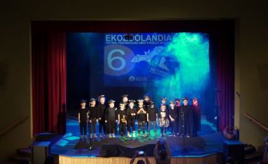 Dzieci występujące na scenie w strojach nietoperzy. W tle jasnoniebieskie światło.