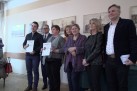 Kobiety i mężczyźni pozujący do zdjęcia. Jedna z kobiet i mężczyzna trzymają w dłoniach dyplomy.