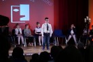 Na scenie uczestnicy odbywającego się wydarzenia. Chłopiec występuje. 