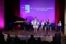Dziewczynka podczas swojego występu. Na scenie również inni uczestnicy konkursu. 