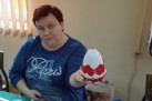 Kobieta prezentująca wykonane jajo wielkanocne. 