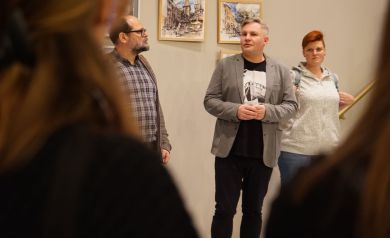 Dwóch mężczyzn opowiada do publiczności na temat sztuki. 