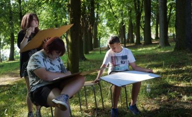 Trójka młodych ludzi maluje swoje obrazy w parku