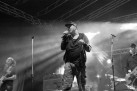 Czarno-białe zdjęcie muzyków występujących na scenie. 