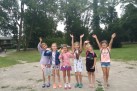 Na zdjęciu sześć dziewcząt. Unoszą ręce w górę i uśmiechają się do zdjęcia.