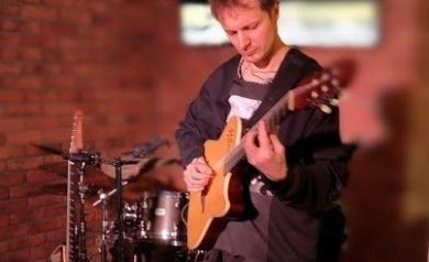 Muzyk grający na gitarze.