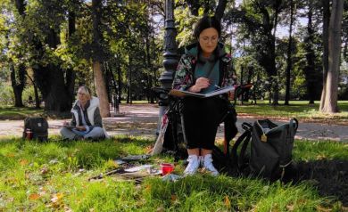 Dwie kobiety siedzące w parku szkicują obrazy