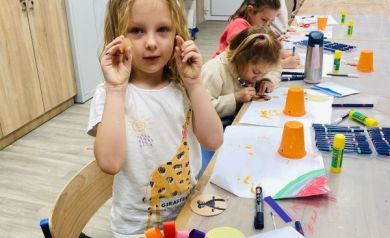 Cztery dziewczynki pracujące nad pracami plastycznymi.