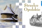 E-kartka z grafikami zabudowy Strzelec Opolskich, herbem oraz złotym napisem ,,Strzelce Opolskie'.  Część kartki jest w kolorze, zaś druga połowa jest czarno-biała. 