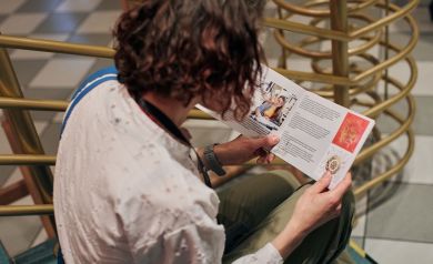 Kobieta siedząca na schodach czyta Katalog Wystawy Międzynarodowej