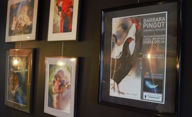 Ściana obrazów oraz plakat promujący wystawę 